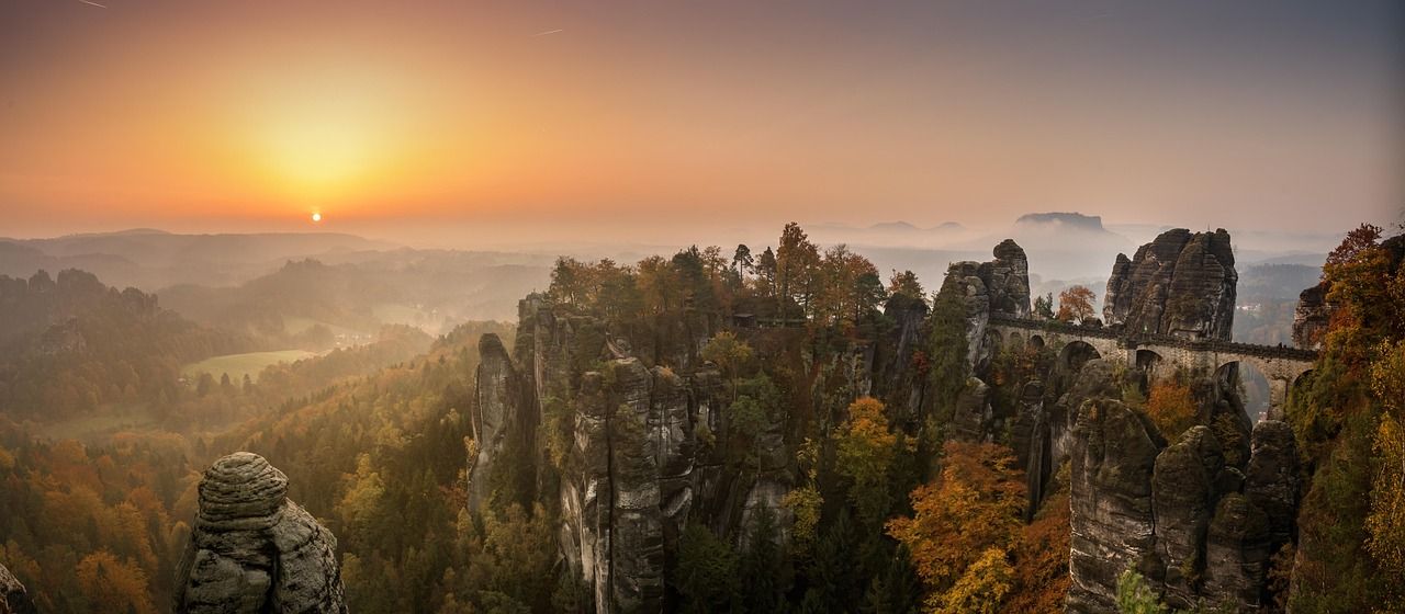 Basteibrücke zwischen den Sandsteinfelsen im Elbsandsteingebirge, Herbstwald und Nebel im Gegenlicht