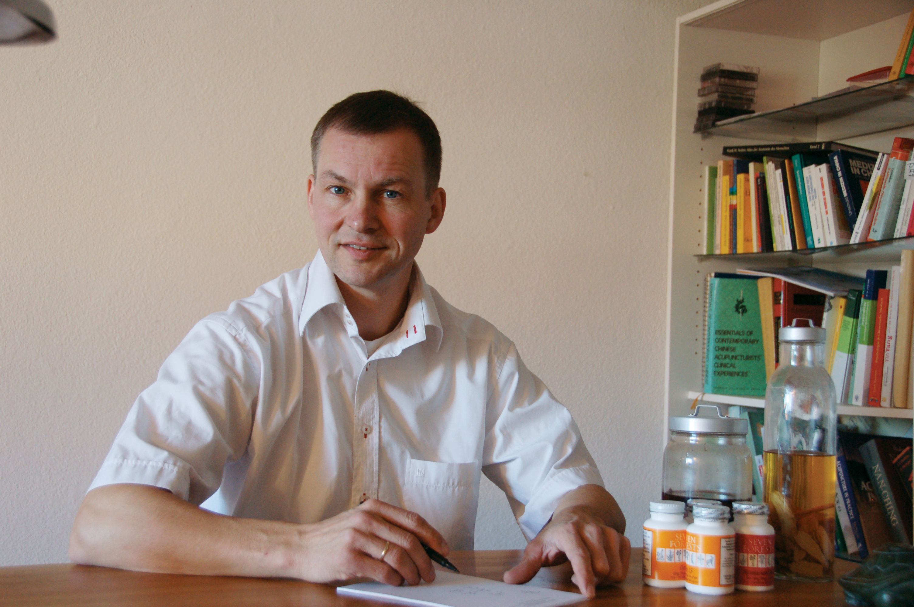Dietrich Rowek am Schreibtisch in der Praxis