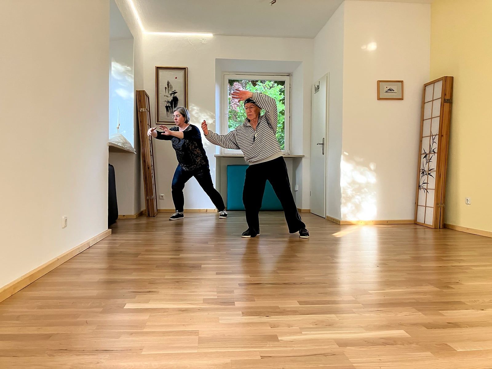 Zwei Teilnehmerinnen üben Tai Chi im Kursraum in der Memminger Straße, Kempten